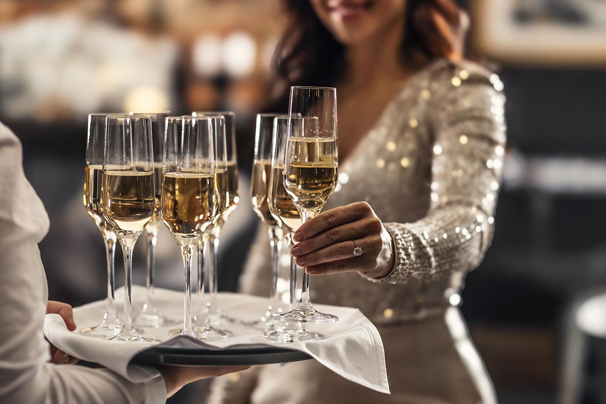 Woman reaching for champagne glass
